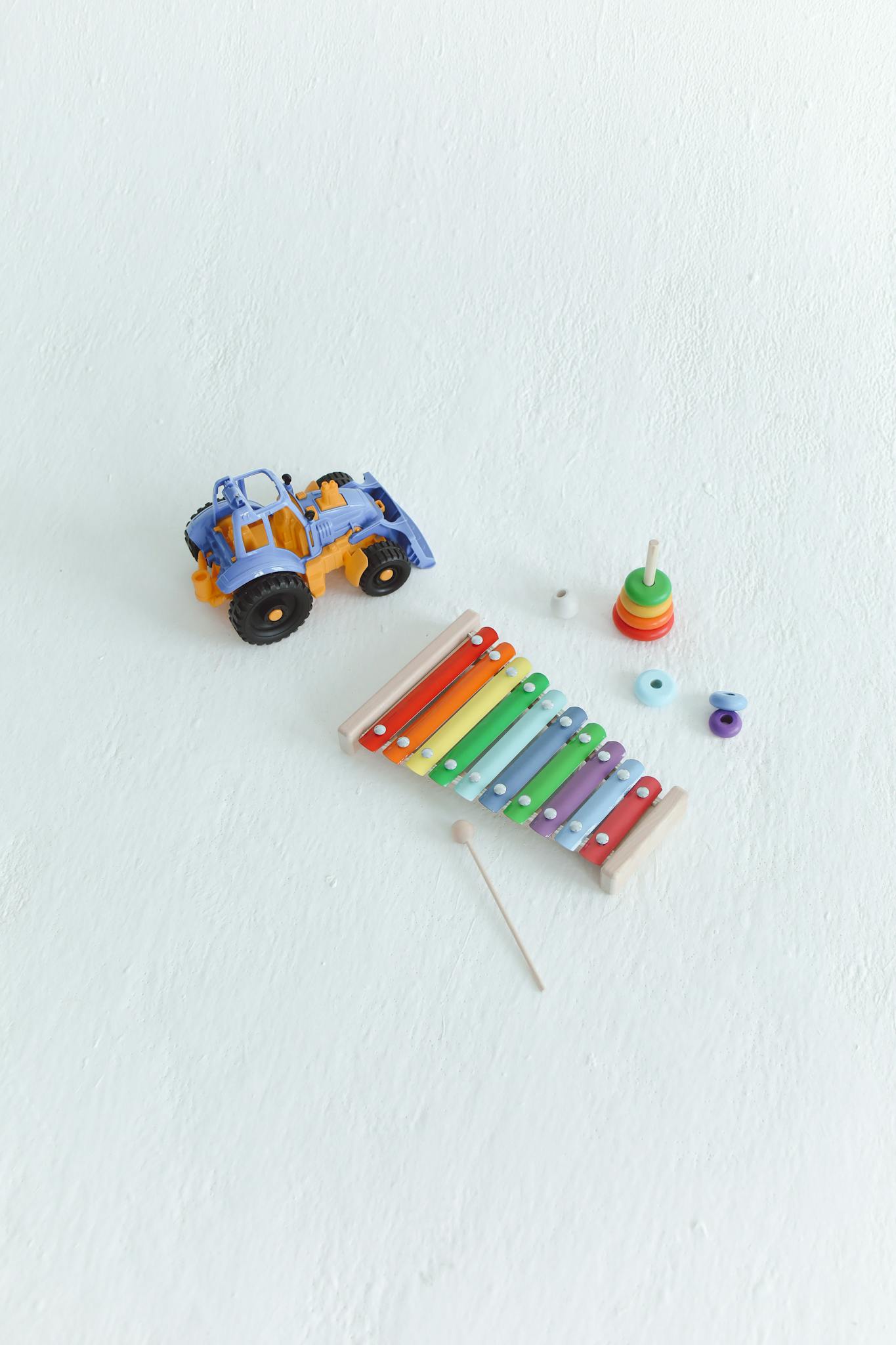 Brightly colored xylophone, stacking rings, and toy truck on a white background.